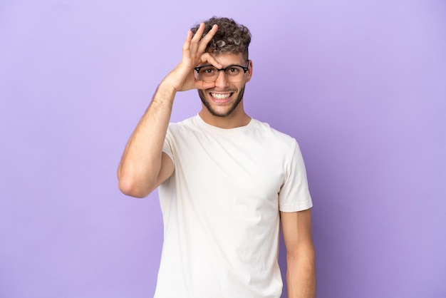 Delivery caucasian man isolated on purple background showing ok sign with fingers