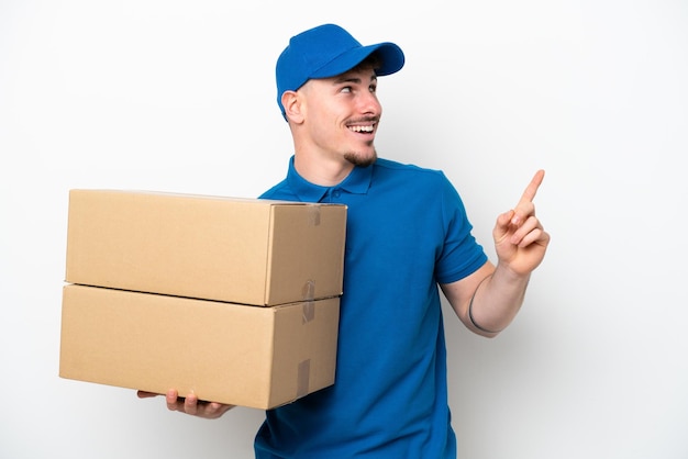 Delivery caucasian man isolated on white background pointing up a great idea