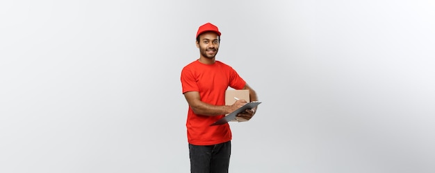 Delivery Concept Portrait of Handsome African American delivery man or courier writing on a order document Isolated on Grey studio Background Copy Space