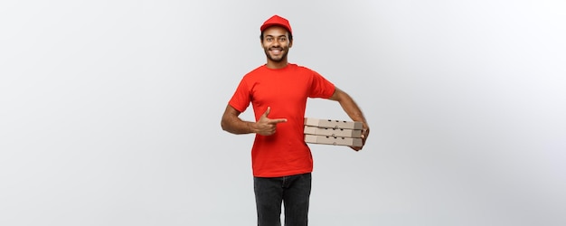 Delivery Concept Portrait of Happy African American delivery man pointing hand to present a box package Isolated on Grey studio Background Copy Space