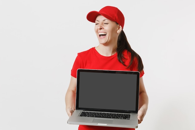 Delivery concept. Woman in red cap, t-shirt isolated on white background. Professional caucasian female working as courier holding pc computer with blank empty screen to copy space for advertisement.