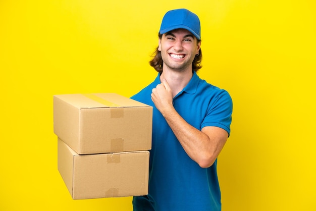 Delivery handsome man isolated on yellow background celebrating a victory