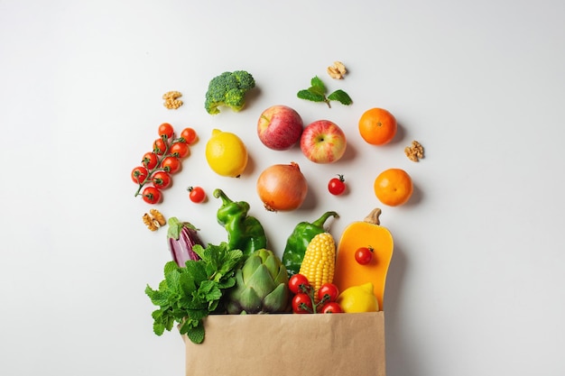 Delivery healthy food background. Healthy vegan vegetarian food in paper bag vegetables and fruits on white. Shopping food supermarket and clean vegan eating concept.