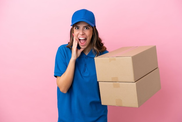 Delivery Italian woman isolated on pink background with surprise and shocked facial expression