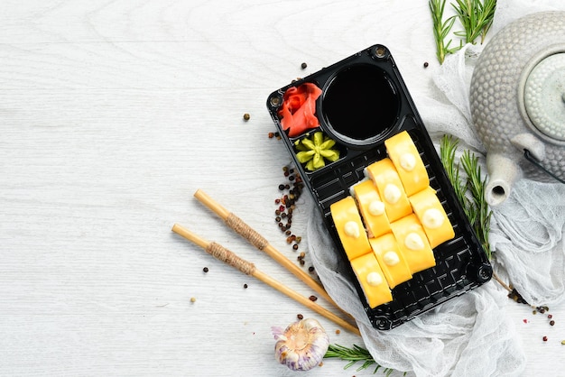 Delivery Japanese food Sushi rolls with cheese wasabi and soy sauce in a plastic box Top view