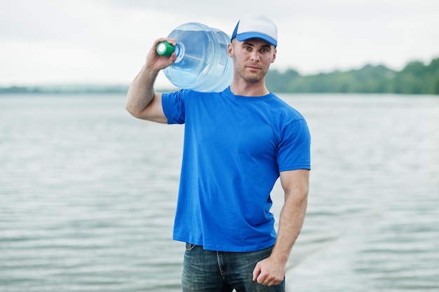 Delivery man carrying water bottle on shoulder.