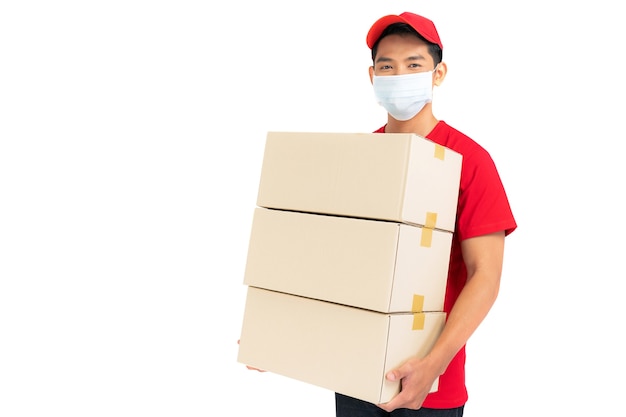 Delivery man employee in red t-shirt uniform face mask holding empty cardboard box isolated on white background