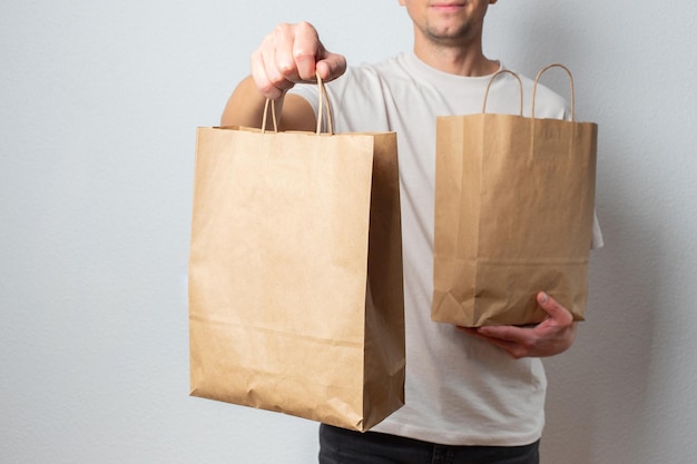 Delivery man holding paper bag with food in the entrance