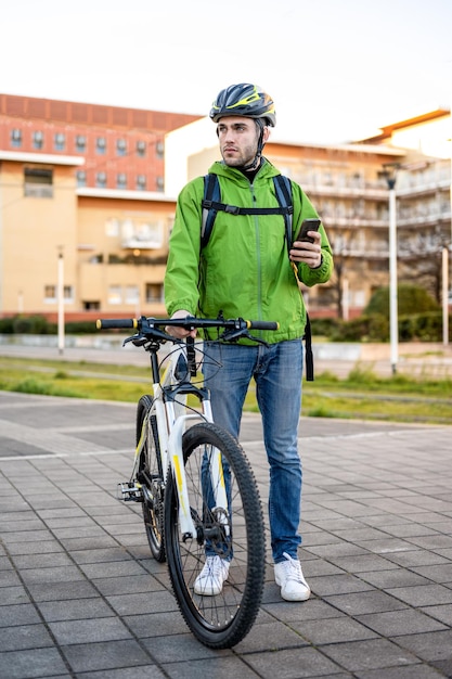 Delivery man looking for address young rider using mobile application and city map for searching the customer ecologic fast courier new business