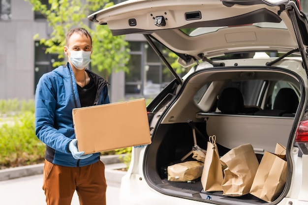 delivery man in a medical mask and gloves delivers the parcel. Quarantine, coronavirus, isolation.