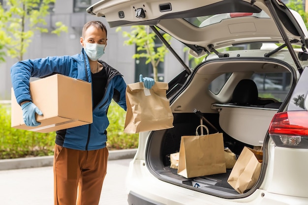 delivery man in a medical mask and gloves delivers the parcel. Quarantine, coronavirus, isolation.