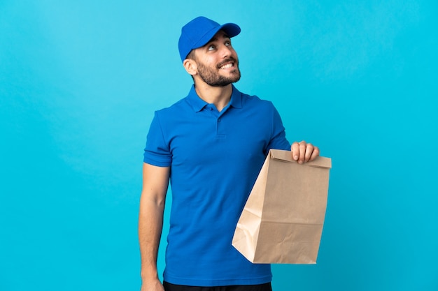 Delivery man with beard isolated on blue