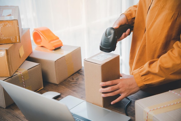 Delivery staff scanning cardboard box with barcode scanner to check products for customers