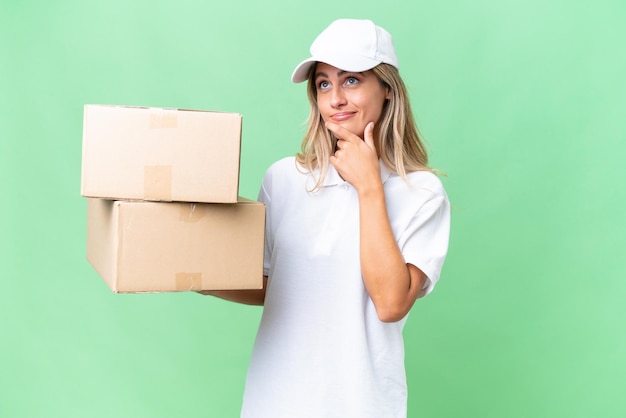 Delivery Uruguayan woman over isolated background having doubts and thinking