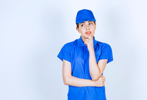 Delivery woman employee in blue uniform standing and posing.