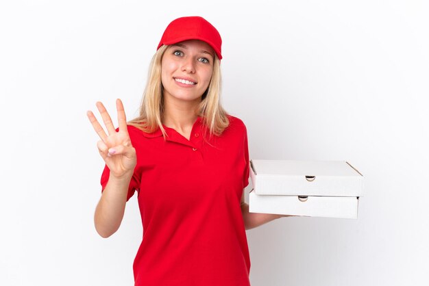 Delivery woman holding pizzas isolated on white background happy and counting three with fingers