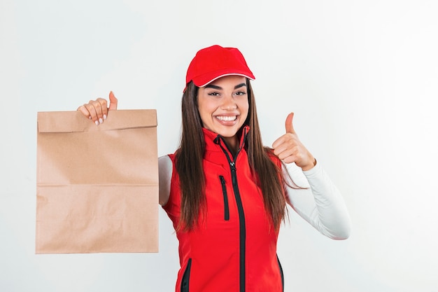 Delivery woman in red uniform hold craft paper packet with food