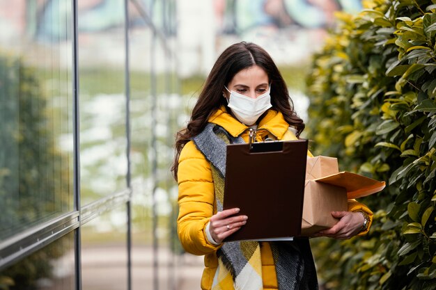 Photo delivery woman with mask carrying package