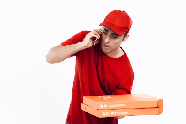 Deliveryman in Orange Uniform Speaks into Phone.