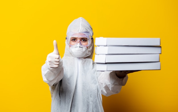 Deliveryman in protection clothes with pizza boxes