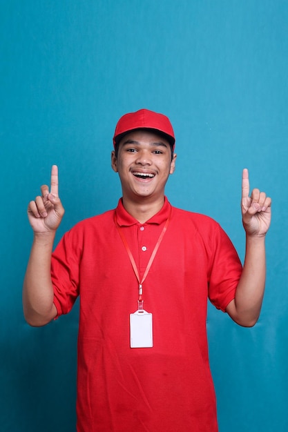 Deliveryman in red cap T-shirt uniform workwear work as dealer courier point fingers up