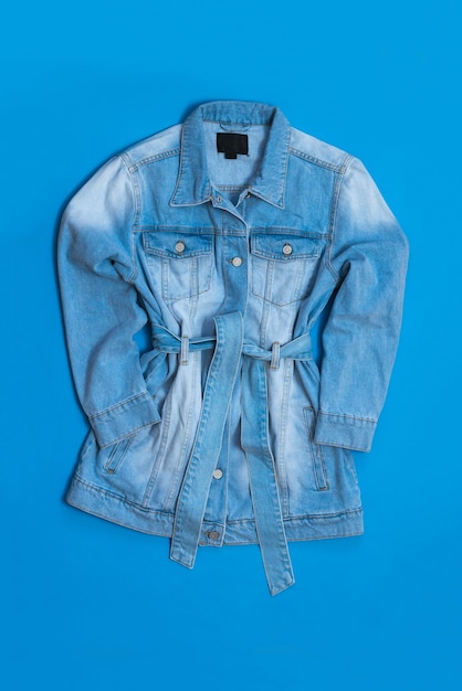 Denim coat for women on a bright blue background Fashionable women's denim clothing