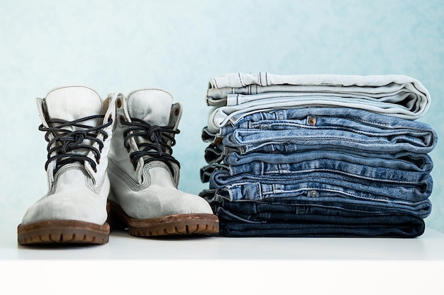 Denim Collection Stack of jeans and pair of boots Casual clothing Sale concept