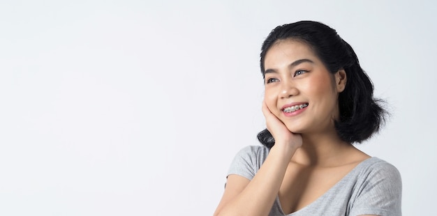 Dental braces of teen asian woman wearing braces teeth and contact lenses she very confident and proudly present herself and smile on white wall Happiness teenager smiling