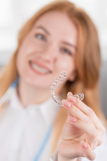 Dental care Smiling orthodontist doctor holding teeth aligners in hands