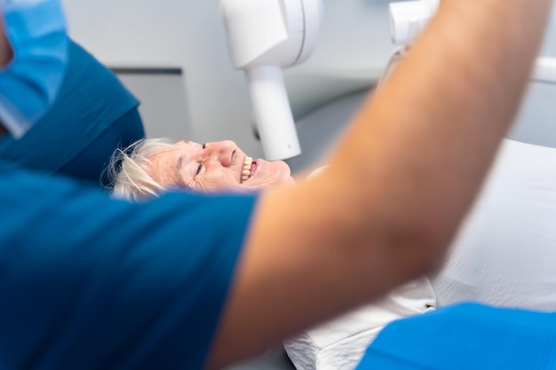 Dental clinic elderly woman sitting smiling at the dentist waiting for denture checkup