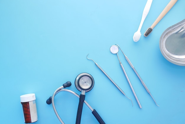 dental equipment  stethoscope and pill container on blue