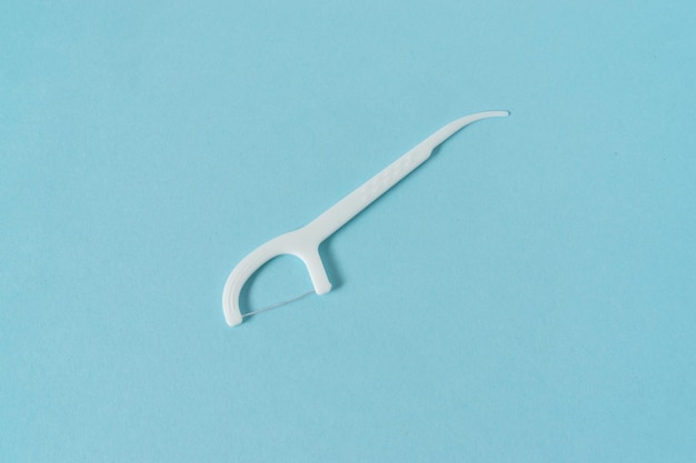 A dental floss picks on blue background.