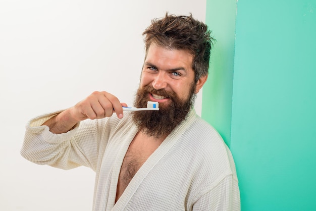 Dental higiene bearded man brushing teeth with toothbrush oral care smiling young man with