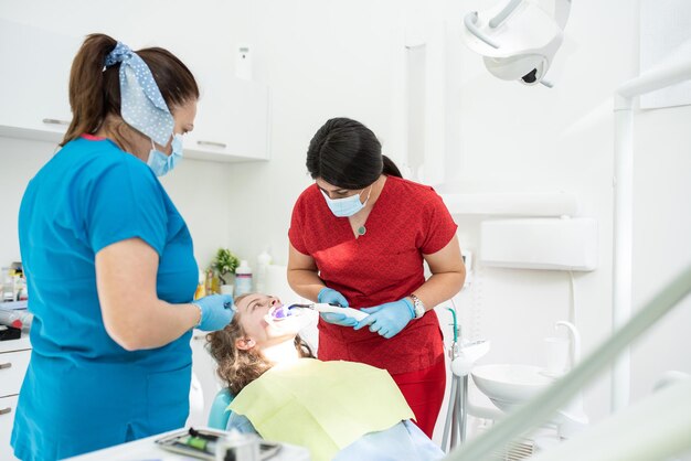 Dentist appointment at a dental clinic placing braces locks on the teeth and pulling the archwire to fix it