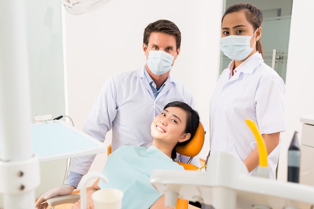 Dentist, assistant and smiling patient