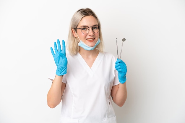 Dentist caucasian woman holding tools isolated on white background happy and counting four with fingers