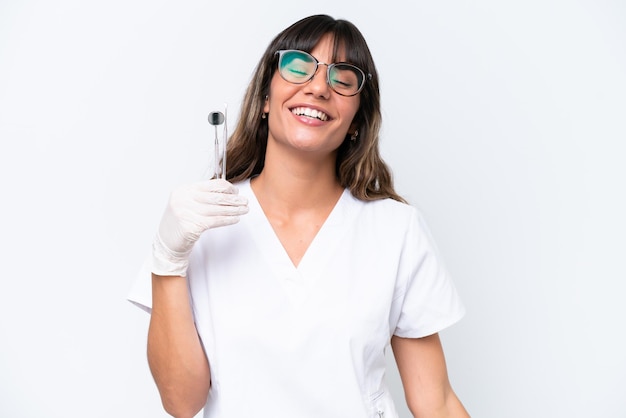 Dentist caucasian woman holding tools isolated on white background laughing