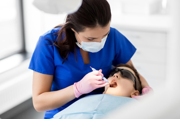 dentist checking for kid teeth at dental clinic