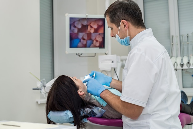 Photo dentist checking patients teeth with camera in stomatology