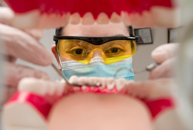 A dentist cleaning a mouth inside view Inside view of a mouth checked by a dentist a female dentist checking a patient dentist checking a mouth a dentist cleaning teeth