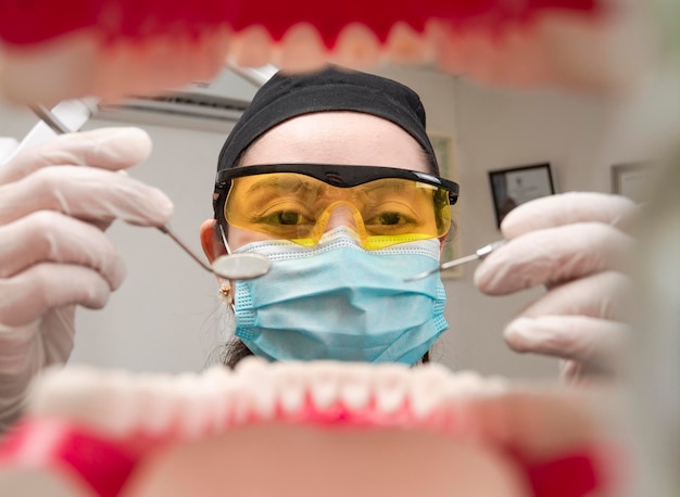 A dentist cleaning a mouth inside view Inside view of a mouth checked by a dentist a female dentist checking a patient dentist checking a mouth a dentist cleaning teeth