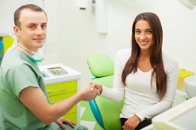 Dentist in dental office talking with female patient and preparing for treatment