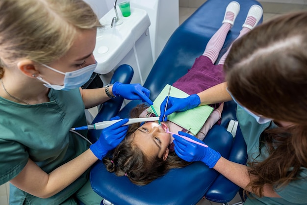 The dentist examine the child's teeth with a camera and display the picture on the screen