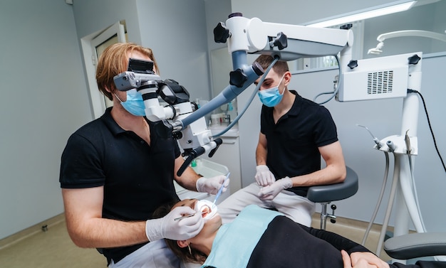 The dentist examines the patient's teeth with a dental microscope. Modern medical equipment. Oral treatment concept. Closeup. Selective focus.