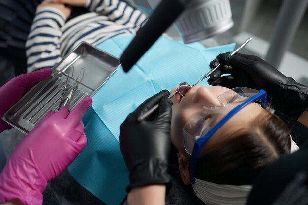 The dentist examines teeth of the child with a microscope. Professional dental equipment.