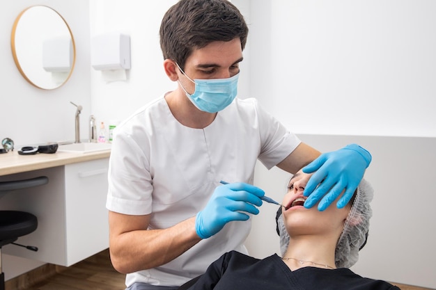 Dentist examining patient teeth with dental mirror Dental check up concept