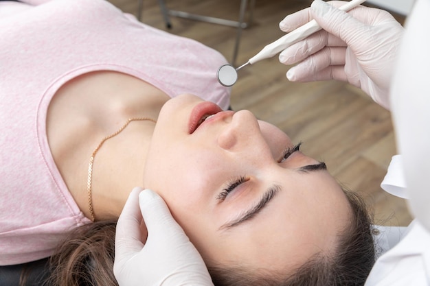 Dentist examining patient teeth with dental mirror during dental check up