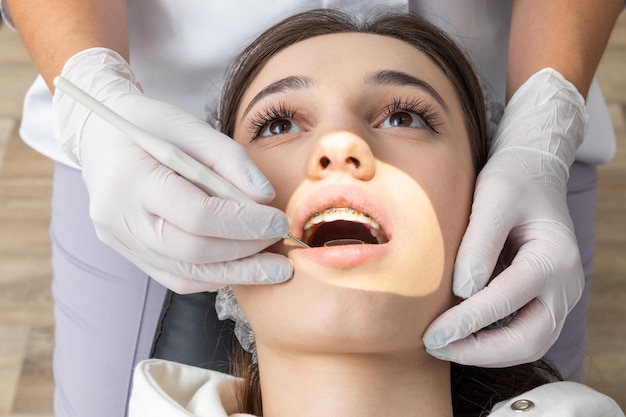 Dentist examining patient teeth with mirror in dentist clinic