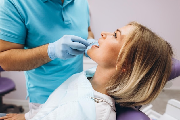 Photo dentist humidifies woman's lips gel