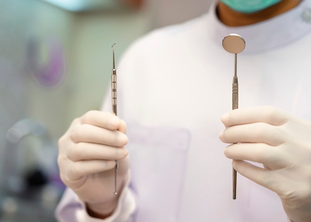 Dentist is holding model teeth on hand.